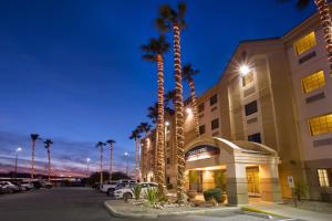 a hotel with palm trees in front of a building at Candlewood Suites Yuma, an IHG Hotel in Yuma