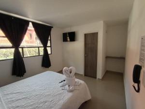 1 dormitorio con cama blanca y ventana en HOSPEDAJE SiLOM, en Bogotá