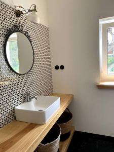 Un baño con un lavabo blanco y un espejo. en Pod Modrzewiem, en Sokołowsko