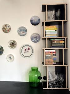 un estante con placas y vasos en la pared en Pod Modrzewiem, en Sokołowsko