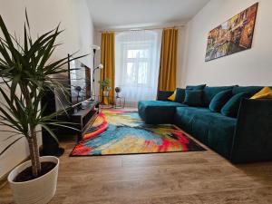 a living room with a blue couch and a colorful rug at Stylový byt v srdci Hradce Králové in Hradec Králové