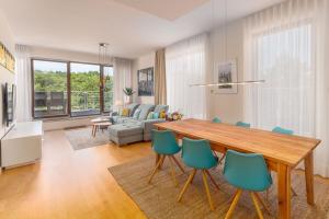 un soggiorno con tavolo in legno e sedie blu di Premium Penthouse E51 3 Schlafzimmer 2 Bäder 103qm PARKING FREE a Międzyzdroje