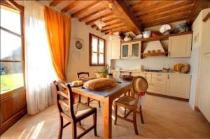 a kitchen with a table and chairs in a room at Ferienwohnung in Badia A Cerreto mit gemeinsamem Pool, Garten und Terrasse in Gambassi Terme