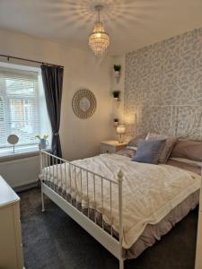 a bedroom with a bed and a chandelier at Lovely flat located in heart of Lynton. in Lynton