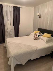 a bedroom with a large white bed and a window at la maison bel air in Limoux