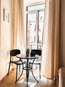 a table and chairs in a room with a window at Monteleone rooms in Palermo