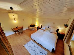 Un dormitorio con una gran cama blanca y un escritorio. en Zirmweg Appartements, en Oberau