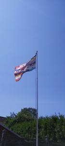 eine Flagge am Himmel neben einem Gebäude in der Unterkunft Ganze Wohnung in Jameln mit Garten, Grill und Terrasse - b57780 in Jameln