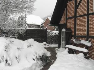 einen schneebedeckten Hof mit einer Bank vor einem Haus in der Unterkunft Ganze Wohnung in Jameln mit Garten, Grill und Terrasse - b57780 in Jameln
