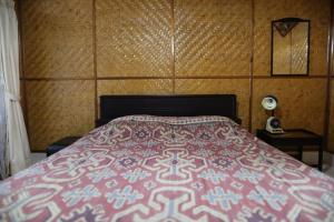 - une chambre avec un lit doté d'un couvre-lit rose et blanc dans l'établissement Monton Guest House, à Rantepao
