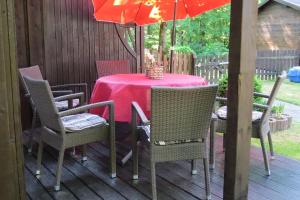 a table with chairs and an umbrella on a deck at Sehr schönes Ferienhaus auf eingezäunten Grundstück mit Kamin und einer Sauna in Extertal