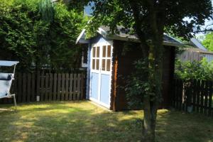 a shed with a blue door in a yard at Sehr schönes Ferienhaus auf eingezäunten Grundstück mit Kamin und einer Sauna in Extertal