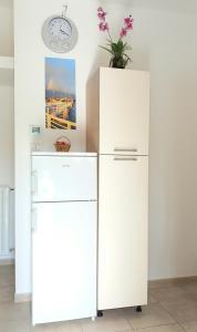 a white refrigerator and a clock on a wall at Casa Bianca in Marina di Massa