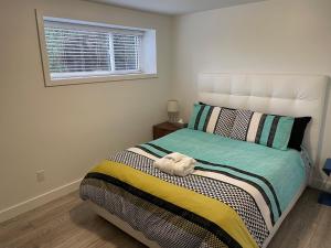 a bedroom with a bed with a stuffed animal on it at Outdoor Adventure ! Large 2 bedroom private suite in North Vancouver