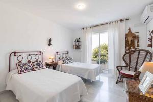 a white bedroom with two beds and a window at Casa Villa Lumar in Almuñécar +27 photos