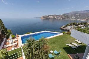 a house with a swimming pool and a view of the ocean at Casa Villa Lumar in Almuñécar