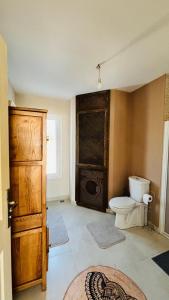 ein Badezimmer mit einem WC und einer Holztür in der Unterkunft Karaçam & Yedigöller doğa evleri in Kemaller