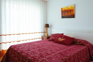 a bedroom with a bed with a red comforter at Casa de Mellares in Melres