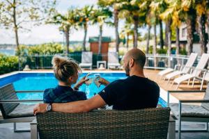 um homem e uma mulher sentados numa mesa junto a uma piscina em Chalet - b57732 em San Felice del Benaco
