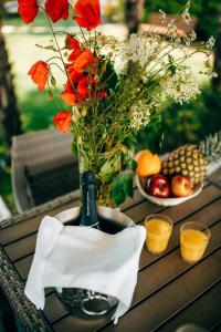 una mesa con una botella de vino y un jarrón de flores en Chalet - b57732, en San Felice del Benaco