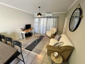 een woonkamer met een bank en een tafel bij Die Mossienes in Windhoek