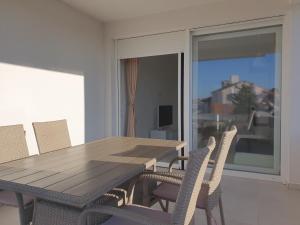a wooden table and chairs in a room with a balcony at Villa Sunny Day Sendi Deluxe Novalja in Novalja