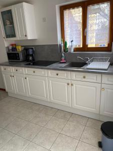 een keuken met witte kasten en een spoelbak bij Gîte Les Acacias in Colmar