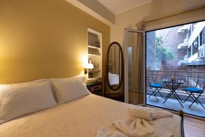 1 dormitorio con cama y vistas a un balcón en Oro's Stylish Kolonaki Flats Next to Metro & Museums, en Atenas