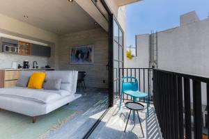 a living room with a couch and a chair on a balcony at Park Condesa by Capitalia in Mexico City