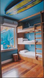 a room with two bunk beds and a window at Longboard Paradise Surf Club in Rio de Janeiro