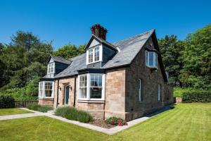 an old brick house with a black roof at South Lodge, Twizell Estate in Belford