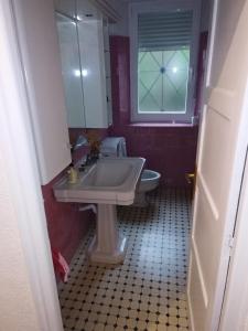 een badkamer met een wastafel, een toilet en een raam bij Casa Ereño in Medina de Pomar