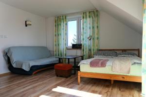 a bedroom with a bed and a couch at Pokoje u Ani in Srokowo