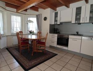 uma cozinha com uma mesa de madeira e cadeiras numa cozinha em Ferienhaus Seehund mit Terrasse und Garten - 300 Meter zum Strand em Otterndorf