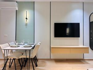 a dining room with a table and a tv on a wall at Luxurious Cozy seaview apartment in Durrës