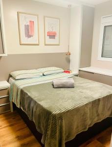 Un dormitorio con una cama con una toalla. en Apartamento Acqua, 102 A, com vaga de garagem en Pelotas