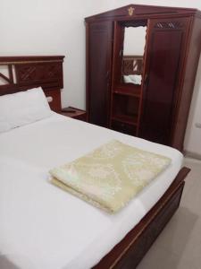 Villa 30 - Marouf Group في رأس البر: غرفة نوم مع سرير مع خزانة خشبية