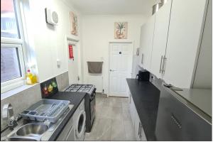 a kitchen with a sink and a washing machine at Happy House in Wyken