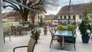 un patio al aire libre con mesas, sillas y plantas en Auberge de Gilly SA, en Gilly