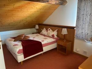 1 dormitorio con cama y techo de madera en Auberge de Gilly SA, en Gilly