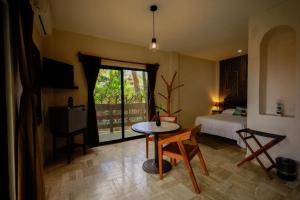 una camera con tavolo, letto e finestra di Hotel Villas Tiburon Adults Only a Isola Holbox