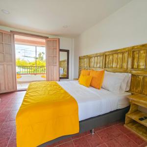 una camera da letto con un letto grande con cuscini gialli di Zenith Bed & Breakfast a Pereira