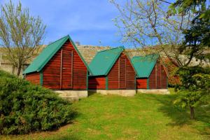 dos graneros rojos con techos verdes en un patio en Seosko domaćinstvo STAREVINA, en Nikšić