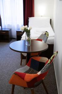 プラハにあるオールド プラハ ハウスのテーブルとベッドが備わるホテルルームです。
