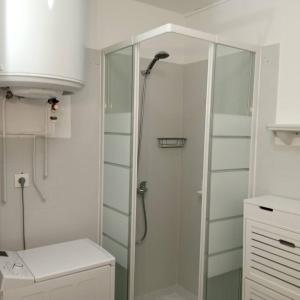 een badkamer met een douche en een glazen deur bij Petit repaire relaxant in Saint-Cyr-sur-Mer