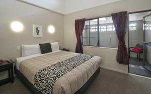 Un dormitorio con una cama grande y una ventana en Sport Of Kings Motel en Rotorua