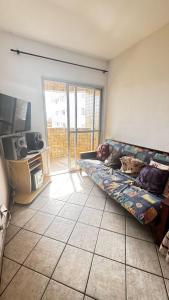 Il comprend un salon doté d'un canapé et d'une télévision à écran plat. dans l'établissement Vila Mirim - Mendes House, à Praia Grande