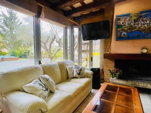 een woonkamer met een bank en een tv bij Villa Lotus by Costabravaway in Calonge