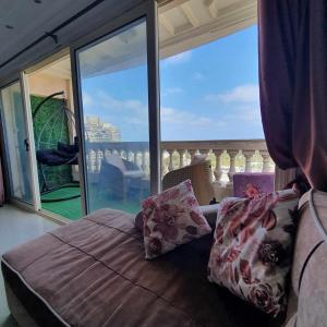 a bedroom with a bed and a large window at Sea and Montaza Palace view 2 bedrooms apartment alexandria,2 full bathrooms, with 2 AC and 1 Stand Fan, wifi, 4 blankets available in Alexandria