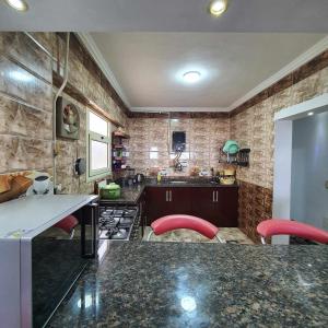 a kitchen with a counter and red stools in it at Sea and Montaza Palace view 2 bedrooms apartment alexandria,2 full bathrooms, with 2 AC and 1 Stand Fan, wifi, 4 blankets available in Alexandria